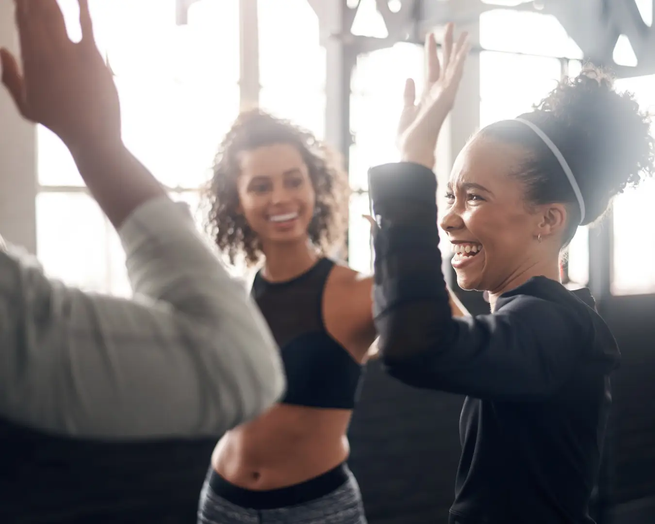 Three people high-fiving after a group fitness class.